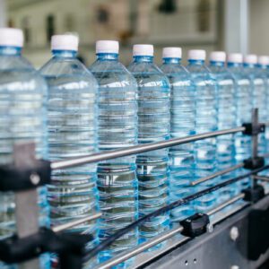 Plastic water bottles lined up on a production line.