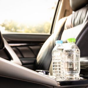 Two water bottles placed on a car's center console.